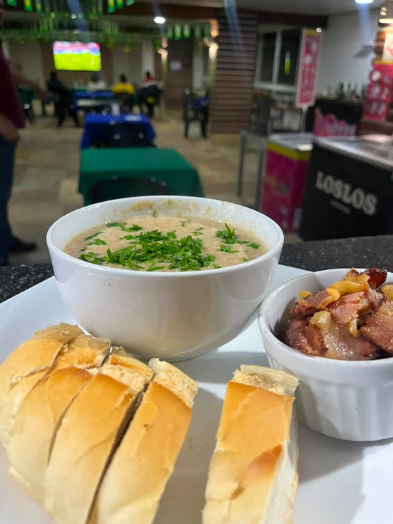 Detalhe da tigela de caldo, pão e acompanhamento no BIMA