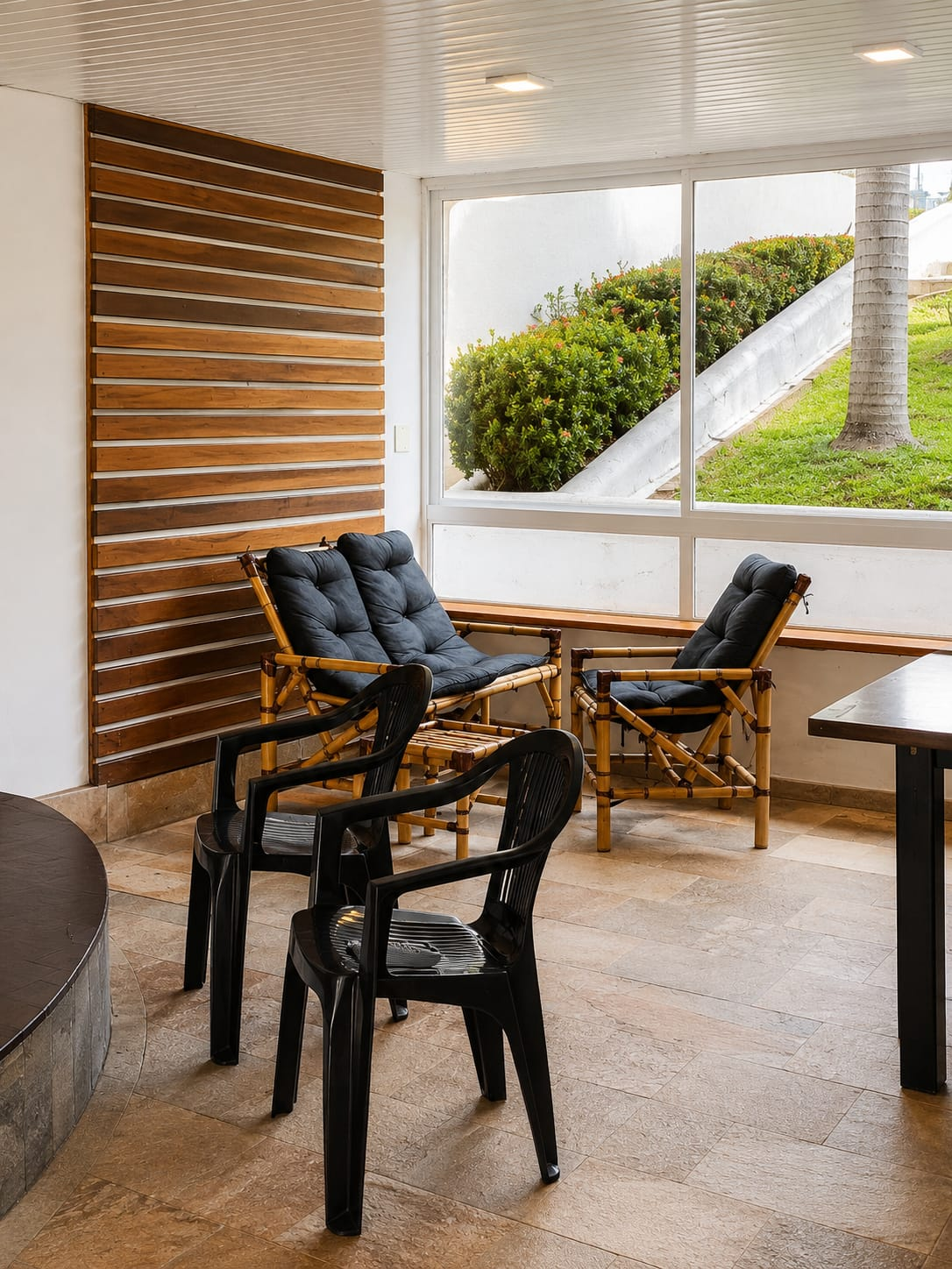 Área de espera do BIMA com poltronas de bambu e vista para o jardim
