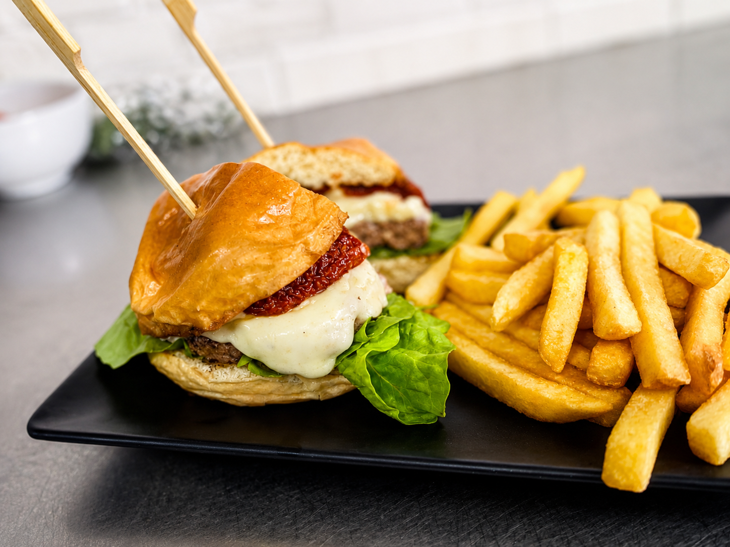 Hambúrguer artesanal com queijo, tomate seco e batatas fritas no BIMA Restaurante